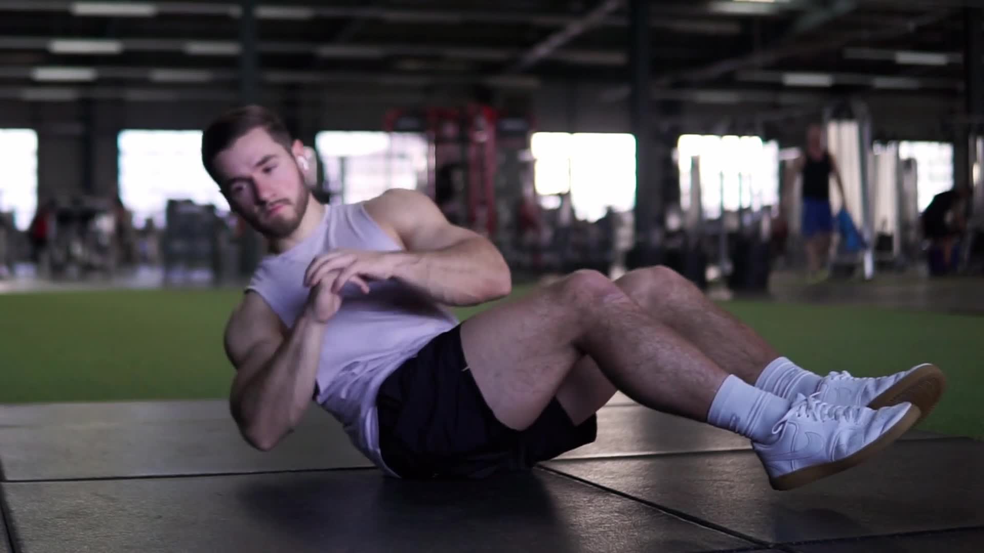 Athlete at full extension of an explosive jump squat in a minimalist concrete gym